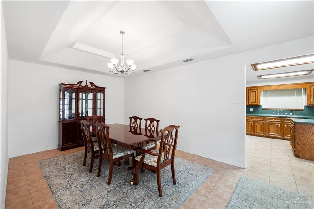 4822 East Canton Road Edinburg, TX 78542 - Photo 7 of 28 a view of a dining room with furniture and a chandelier