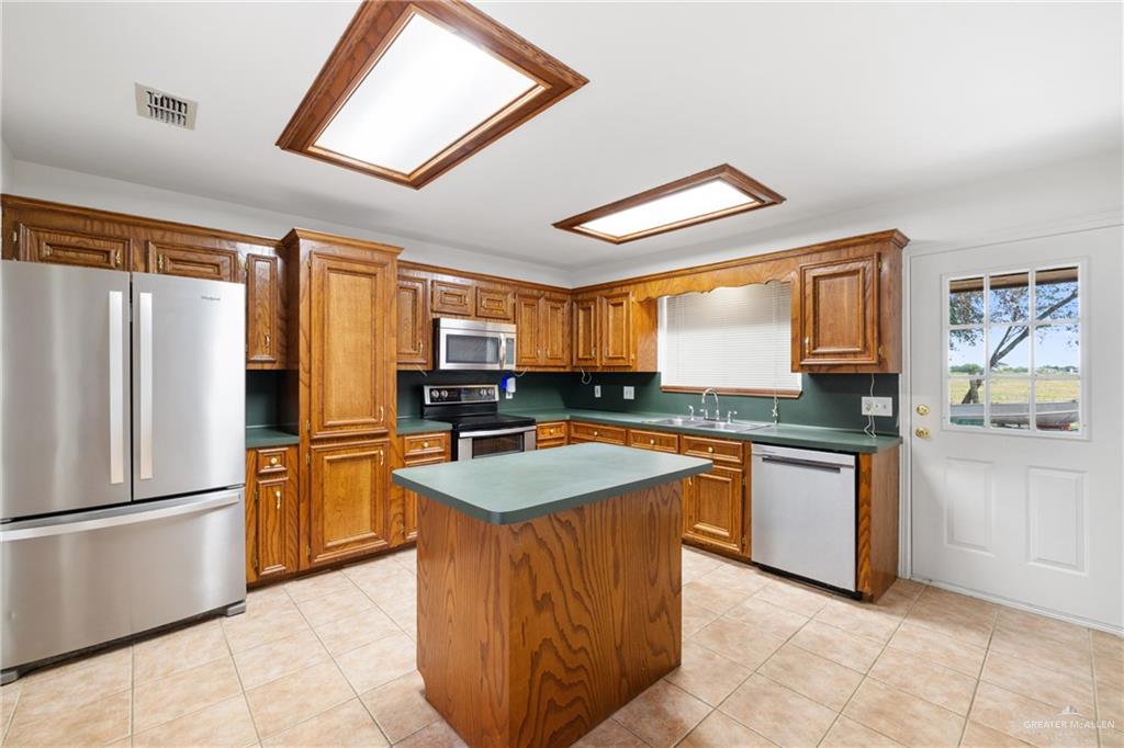 4822 East Canton Road Edinburg, TX 78542 - Photo 8 of 28 a kitchen with stainless steel appliances granite countertop a refrigerator a sink a stove top oven and a refrigerator