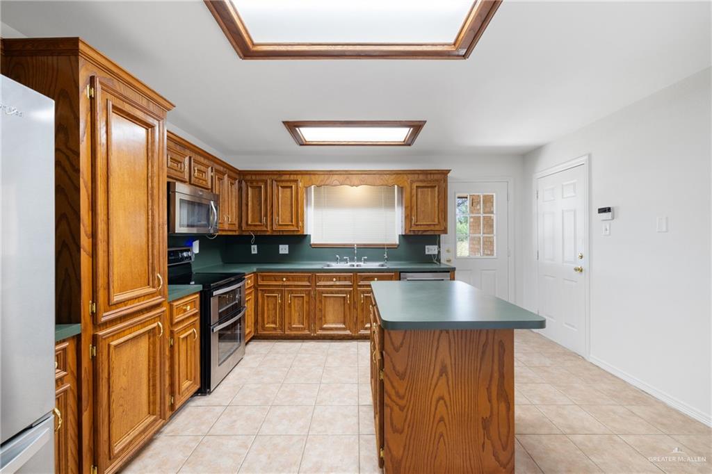 4822 East Canton Road Edinburg, TX 78542 - Photo 9 of 28 a kitchen with stainless steel appliances granite countertop a refrigerator and a stove top oven