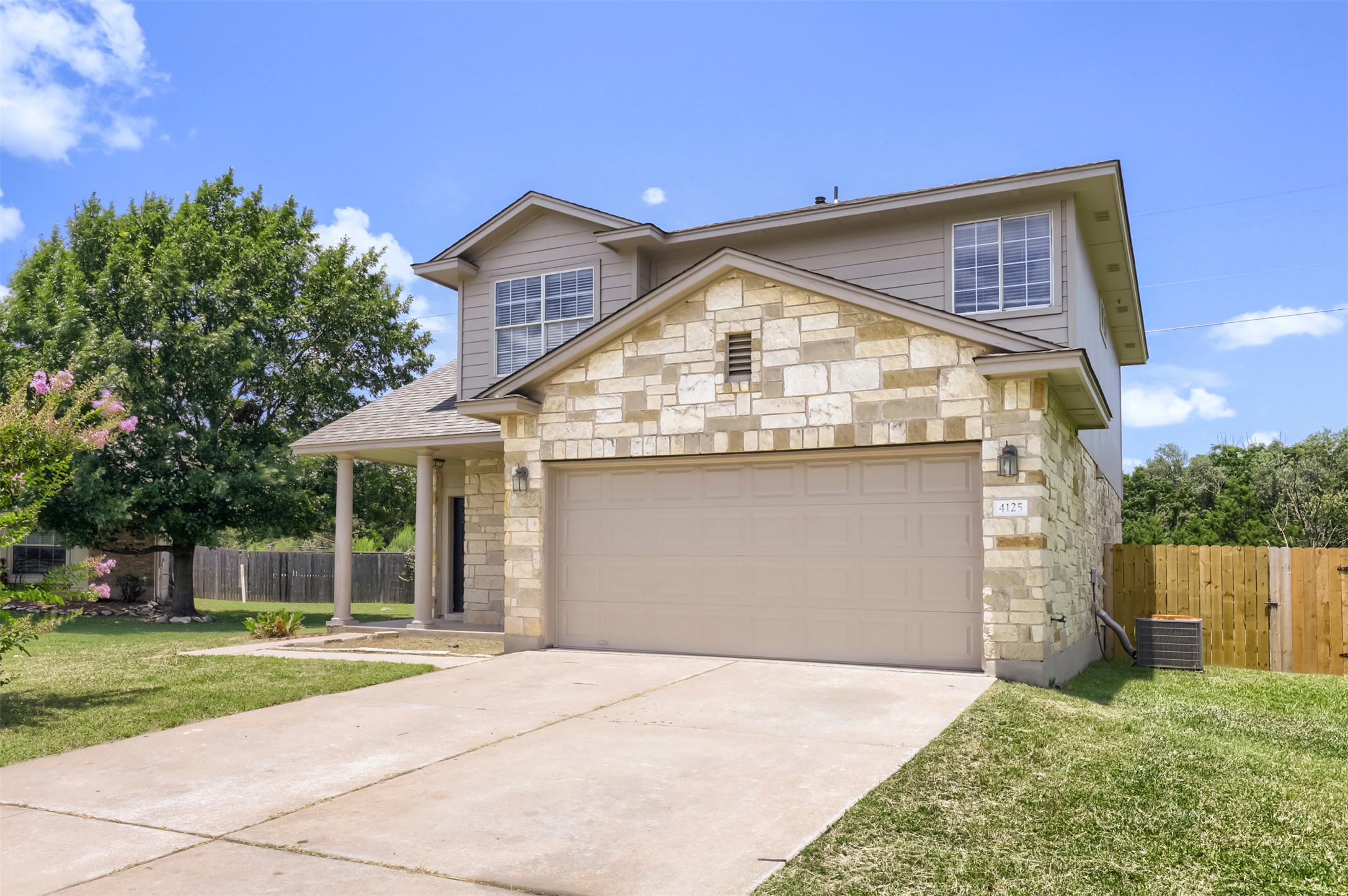A classic facade of stone and siding frames the welcoming entry of this charming residence.