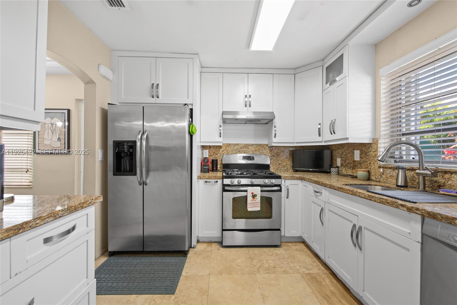 2460 Southwest 24th Street Miami, FL 33145 - Photo 12 of 36 a kitchen with stainless steel appliances granite countertop a refrigerator sink and stove
