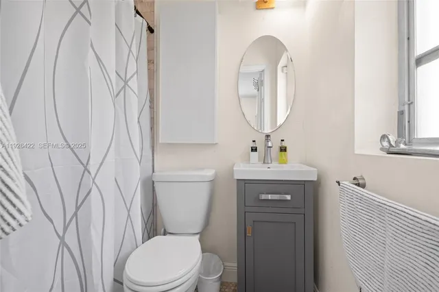 a bathroom with a toilet sink and mirror