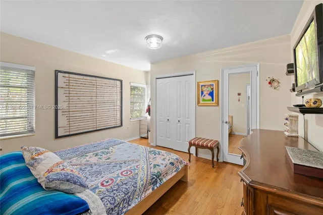a spacious bedroom with a bed and wooden floor