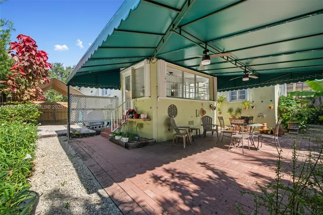 a view of a patio with table and chairs under an umbrella