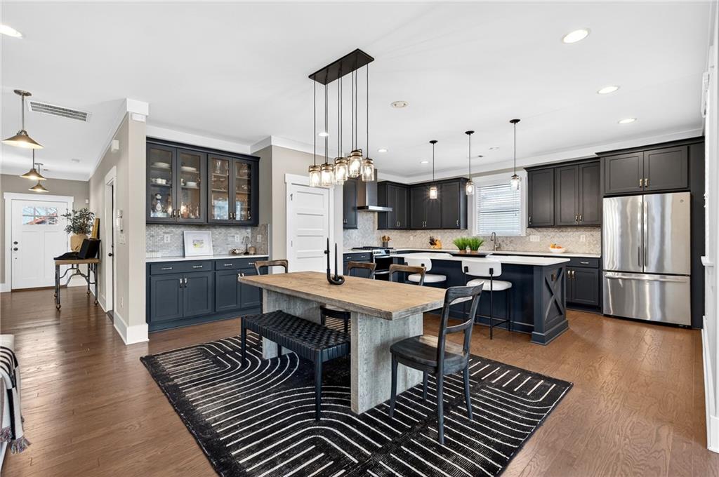 4072 Comanche Drive Tucker, GA 30084 - Photo 13 of 43 a kitchen with stainless steel appliances a refrigerator a stove a sink a dining table and chairs with wooden floor