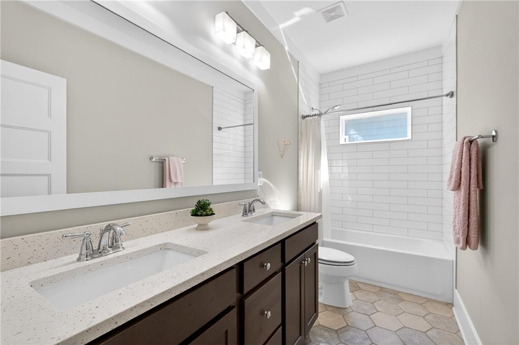 4072 Comanche Drive Tucker, GA 30084 - Photo 33 of 43 a bathroom with a granite countertop sink a toilet a mirror and shower