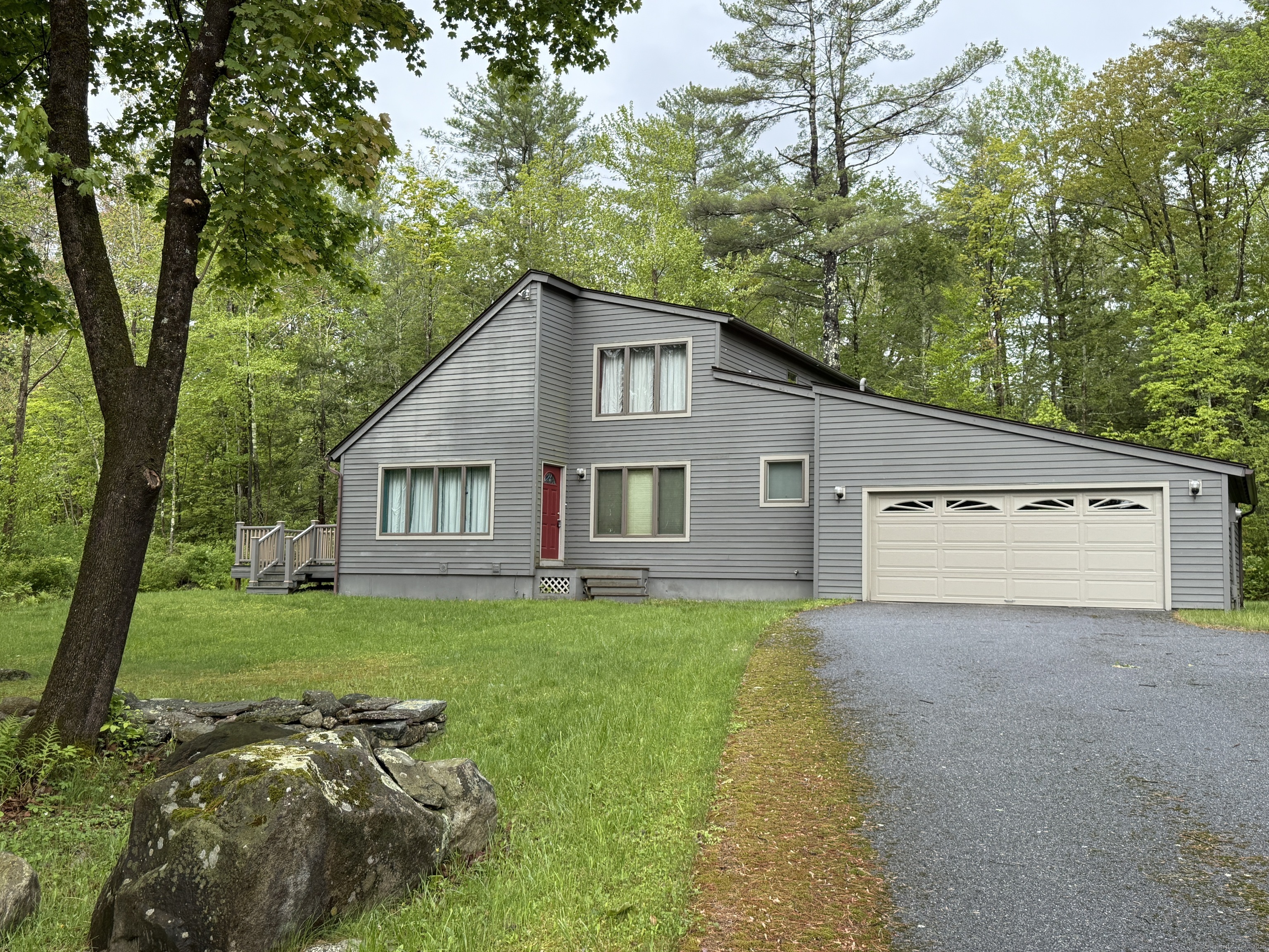 a view of a yard in front of a house with large trees