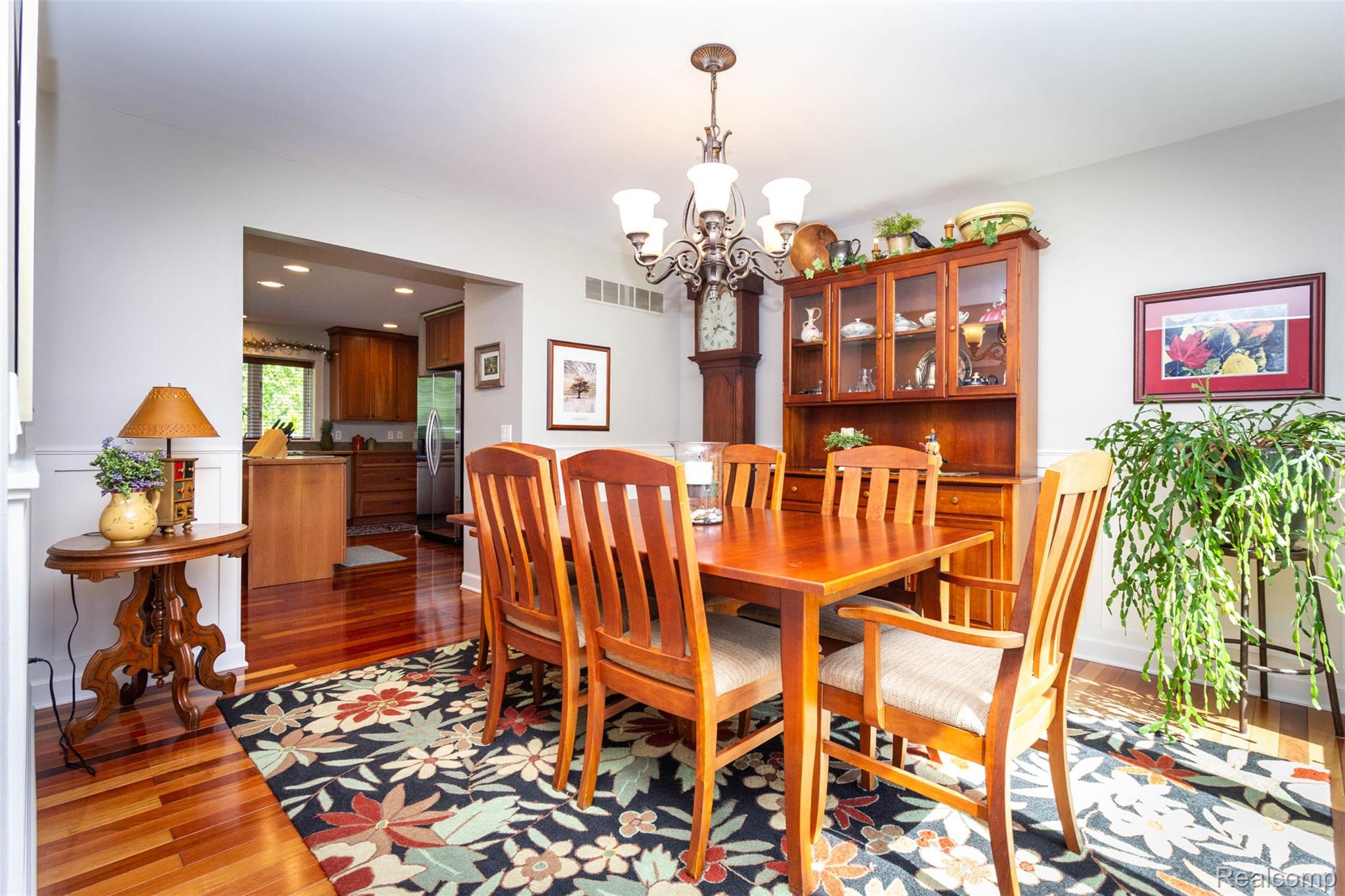 9887 Hadley Road Clarkston, MI 48348 - Photo 16 of 56 Dining area with wood-finish flooring, wainscoting, and an ornate chandelier