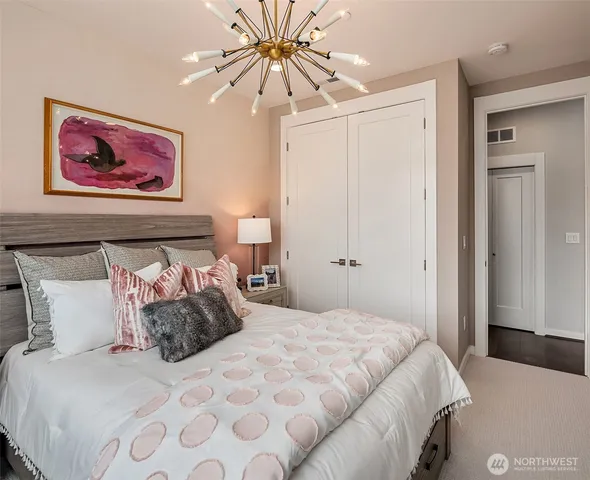 a bedroom with a large bed and a chandelier