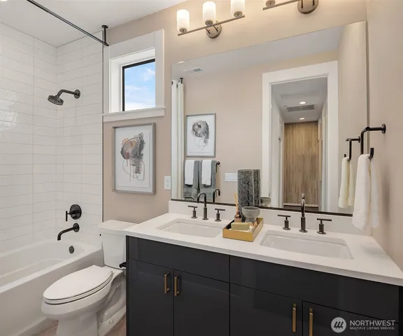 a bathroom with a double vanity sink toilet mirror and shower