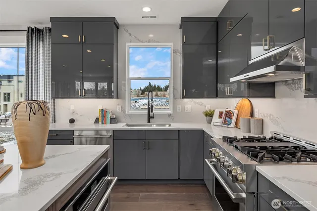 a kitchen with stainless steel appliances granite countertop a sink stove and refrigerator