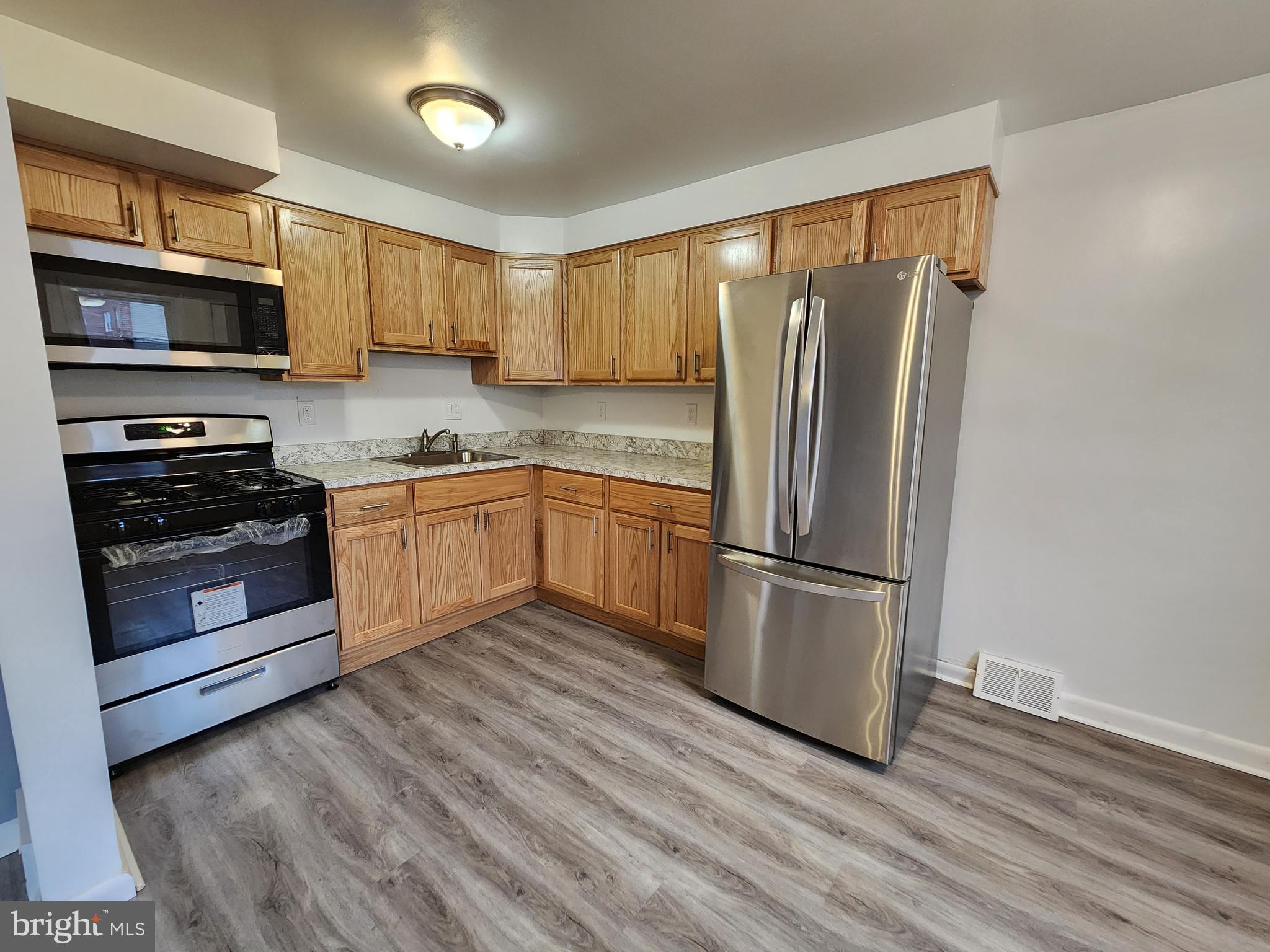 1333 Adair Road Brookhaven, PA 19015 - Photo 7 of 16 a kitchen with stainless steel appliances granite countertop a refrigerator microwave and stove top oven