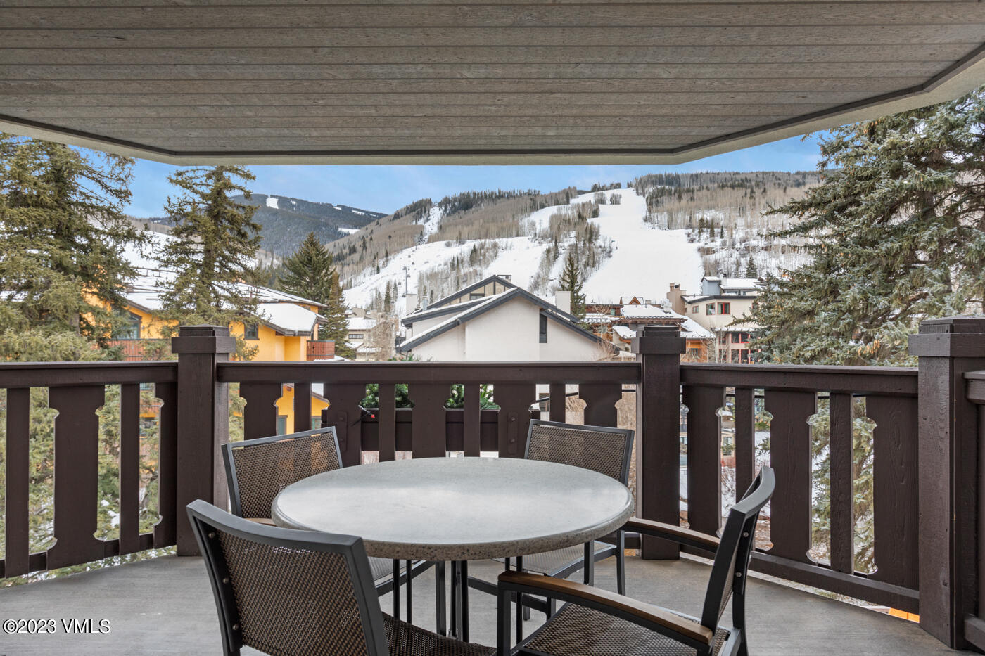 242 East Meadow Drive, Unit 1041 Vail, CO 81657 - Photo 30 of 46 a roof deck with a table and chairs with wooden floor