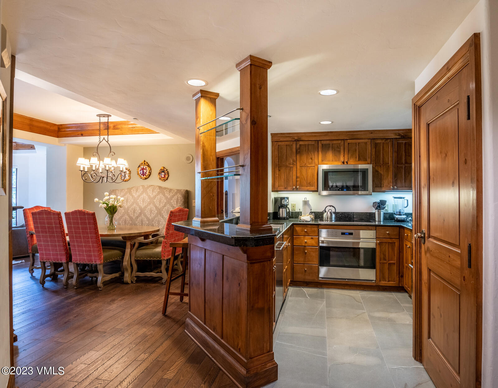 242 East Meadow Drive, Unit 1041 Vail, CO 81657 - Photo 9 of 46 a kitchen with stainless steel appliances a stove top oven a sink a dining table and chairs