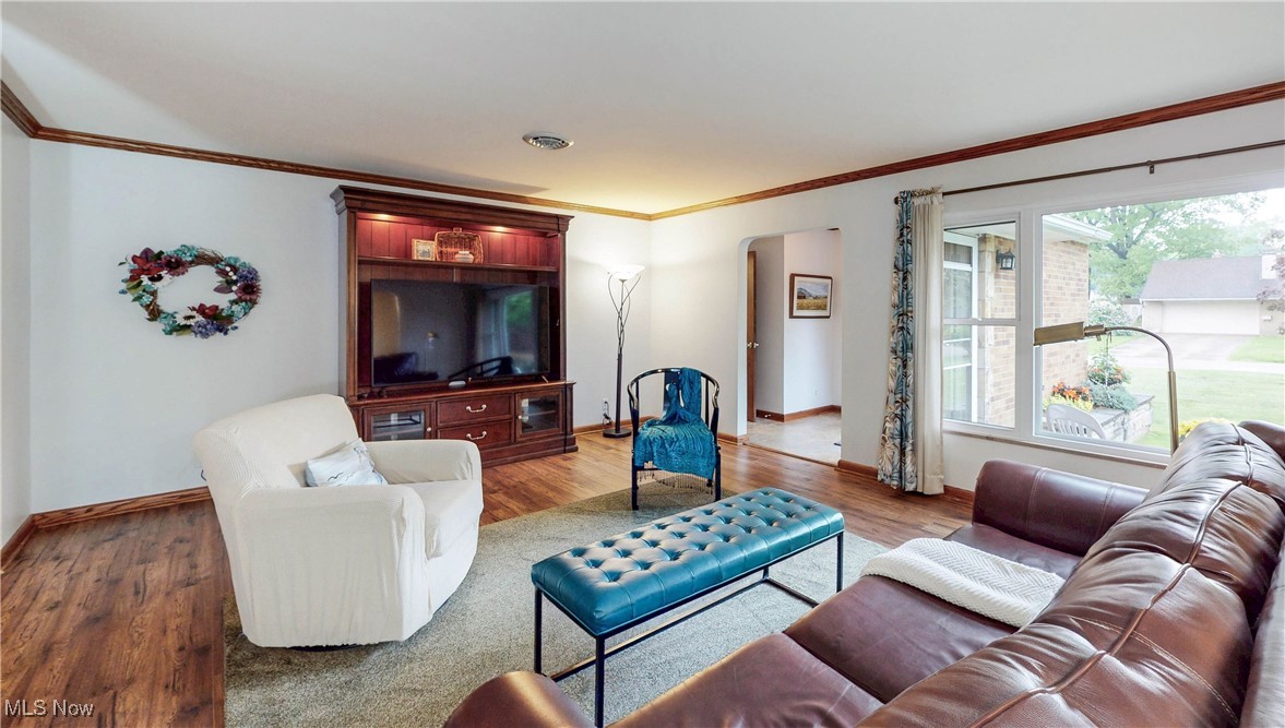 891 Sovereign Road Akron, OH 44303 - Photo 2 of 30 Living area featuring wood finished floors, baseboards, crown molding, and arched walkways