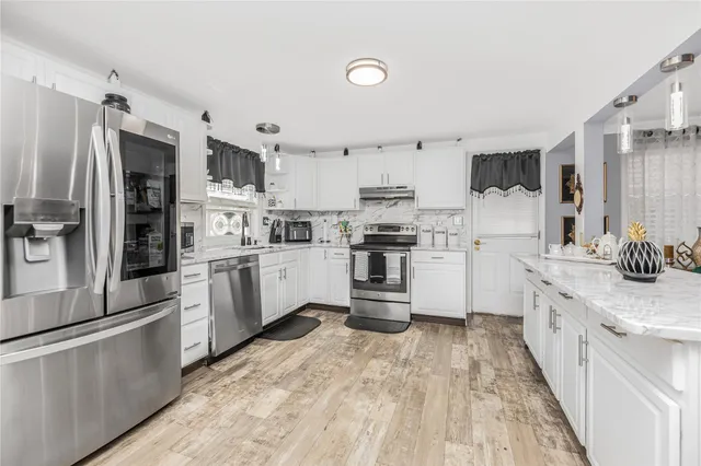 a kitchen with white cabinets and stainless steel appliances