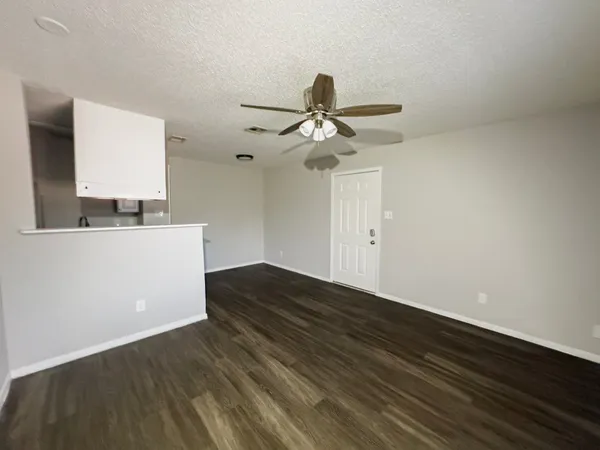 a view of room with wooden floor and ceiling fan