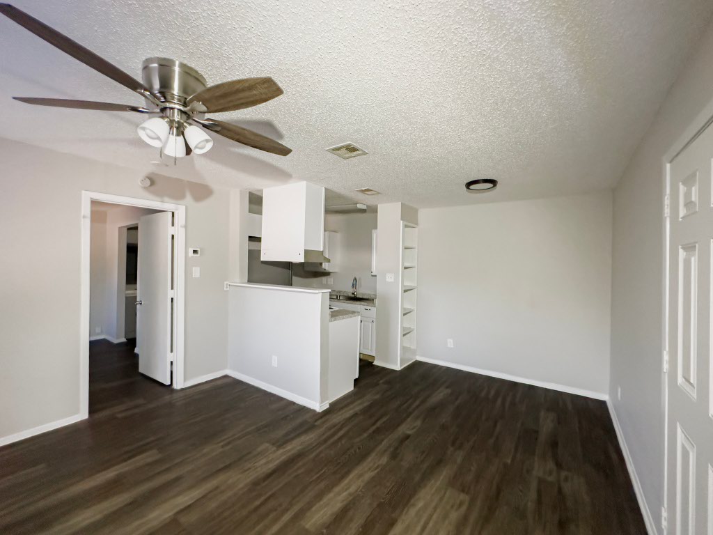 4500 Witham Lane, Unit 101 Austin, TX 78745 - Photo 20 of 27 Unfurnished living room with a textured ceiling, dark wood-style flooring, and a ceiling fan