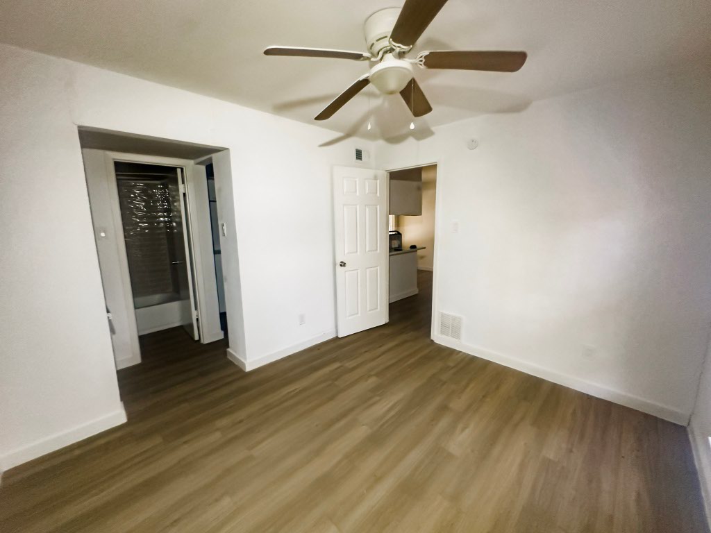 4500 Witham Lane, Unit 101 Austin, TX 78745 - Photo 3 of 27 Unfurnished bedroom featuring dark wood-style floors and ceiling fan