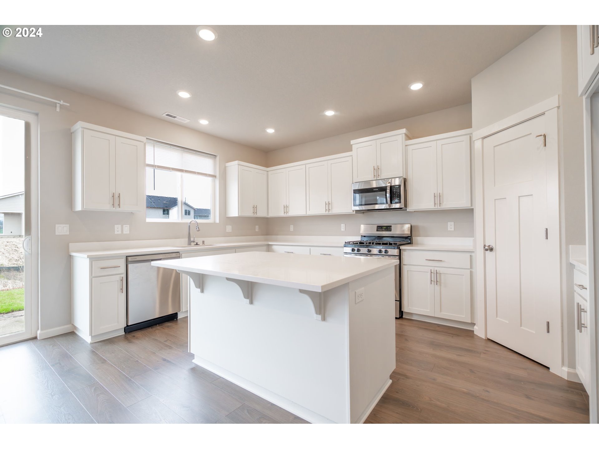 235 Walnut Street Mount Angel, OR 97362 - Photo 11 of 25 a kitchen with a sink a stove a refrigerator a center island and a window