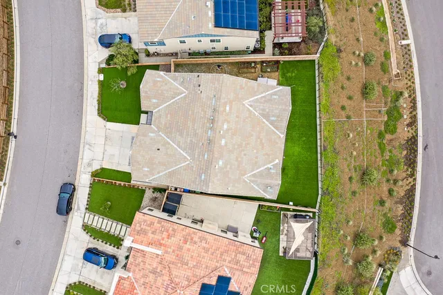 an aerial view of residential houses with outdoor space and trees