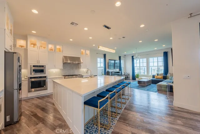 a large kitchen with stainless steel appliances lots of counter space and a wooden floor