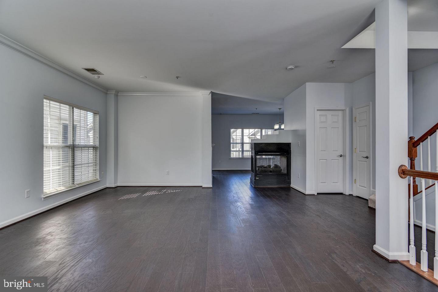640 Main Street, Unit 640B Gaithersburg, MD 20878 - Photo 14 of 65 an empty room with wooden floor fireplace and windows