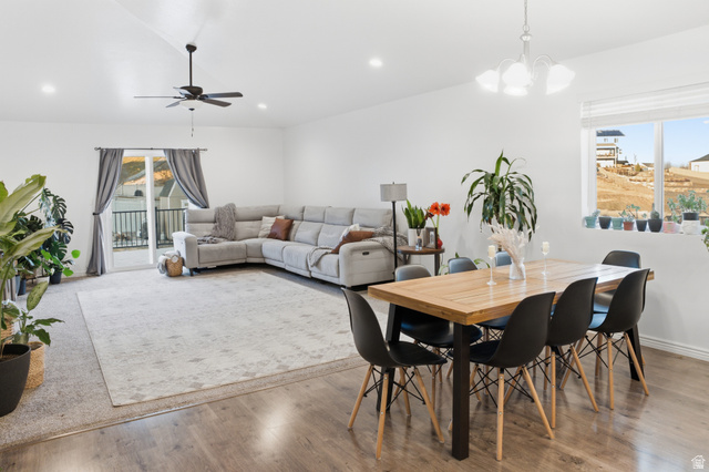 1666 West Foxberry Road Santaquin, UT 84655 - Photo 3 of 24 Open concept living and dining area featuring vaulted ceilings, recessed lighting, wood-finish flooring, and a sliding glass door leading to an outdoor balcony