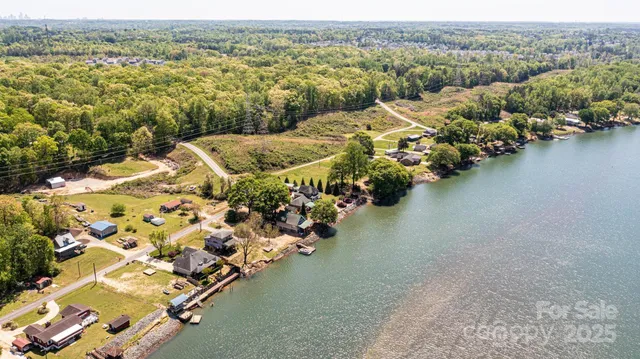 an aerial view of a house with a yard swimming pool and lake view