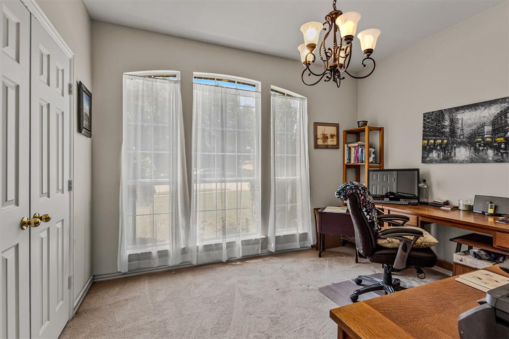 9301 Nottingham Court Rowlett, TX 75088 - Photo 14 of 39 Bright room featuring three arched top windows, neutral-toned wall paint, and a decorative five-light chandelier