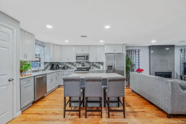 a kitchen with stainless steel appliances granite countertop a table and chairs