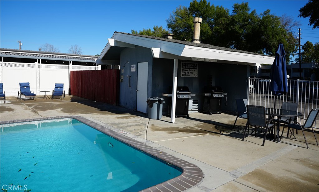 6545 Wilbur, Unit 39 Reseda, CA 91335 - Photo 26 of 27 a view of a patio with table and chairs near an umbrella
