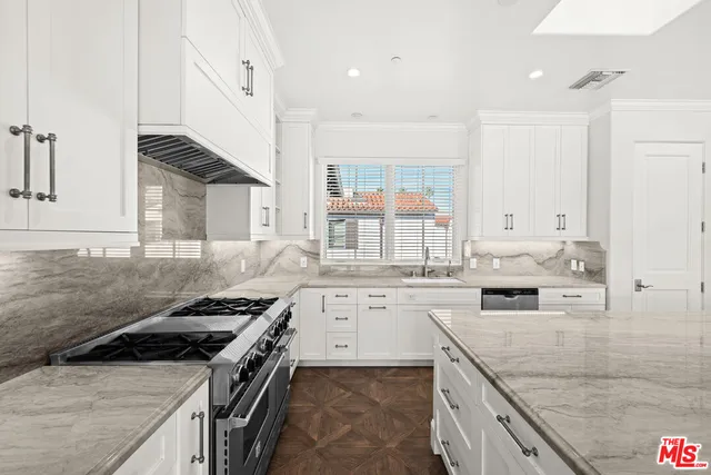 a kitchen with a stove sink and cabinets