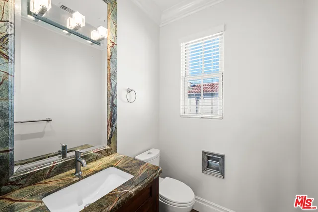 a bathroom with a granite countertop sink toilet a mirror and shower