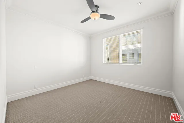 an empty room with wooden floor ceiling fan and windows