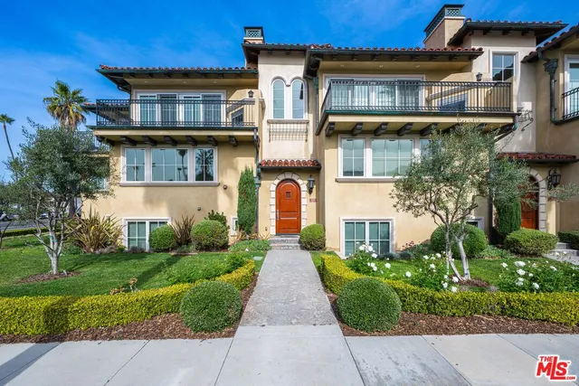 a front view of a house with a yard and trees