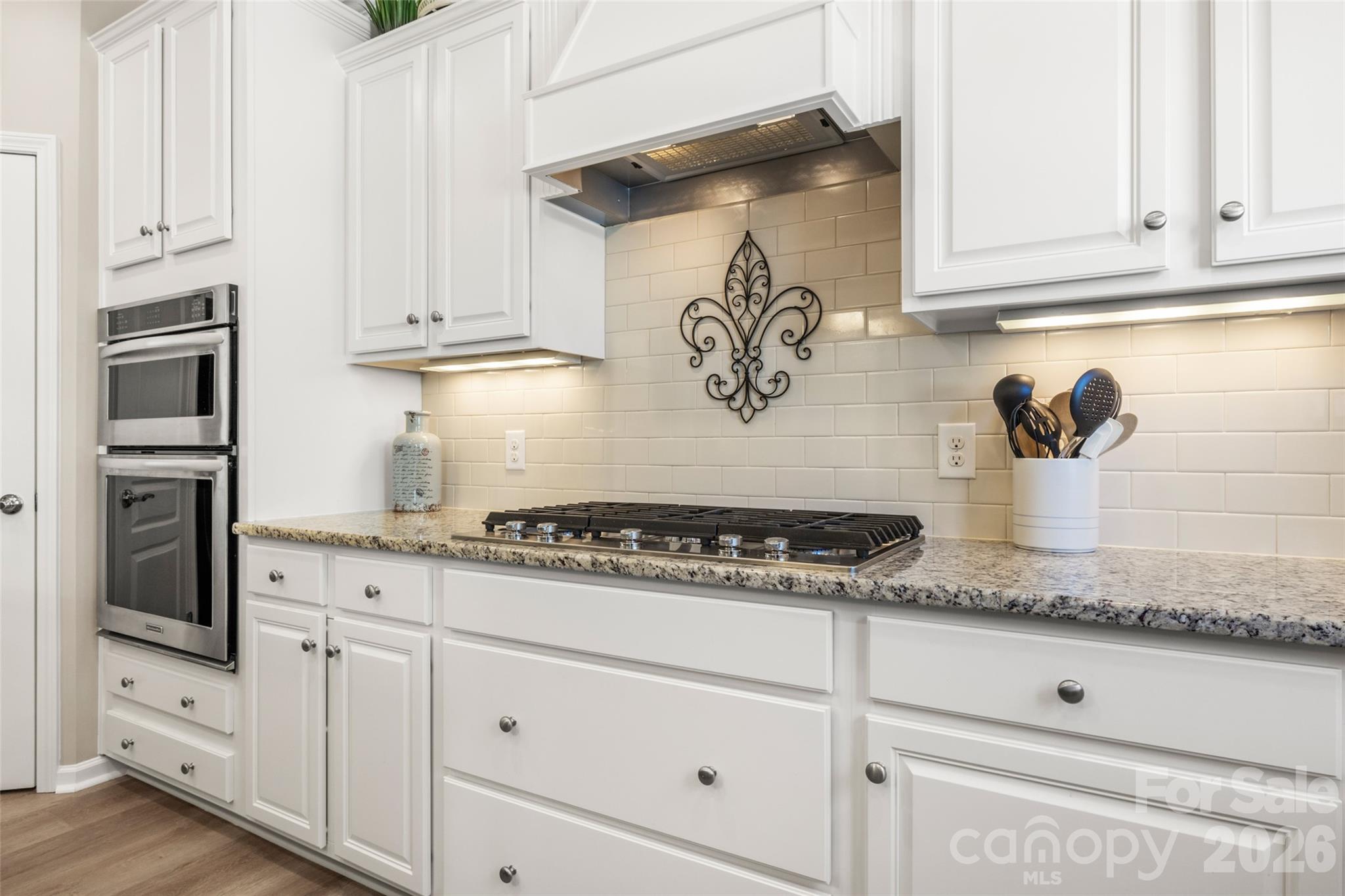 1002 Falling Leaf Street Indian Land, SC 29707 - Photo 4 of 45 a kitchen with white cabinets and a stove