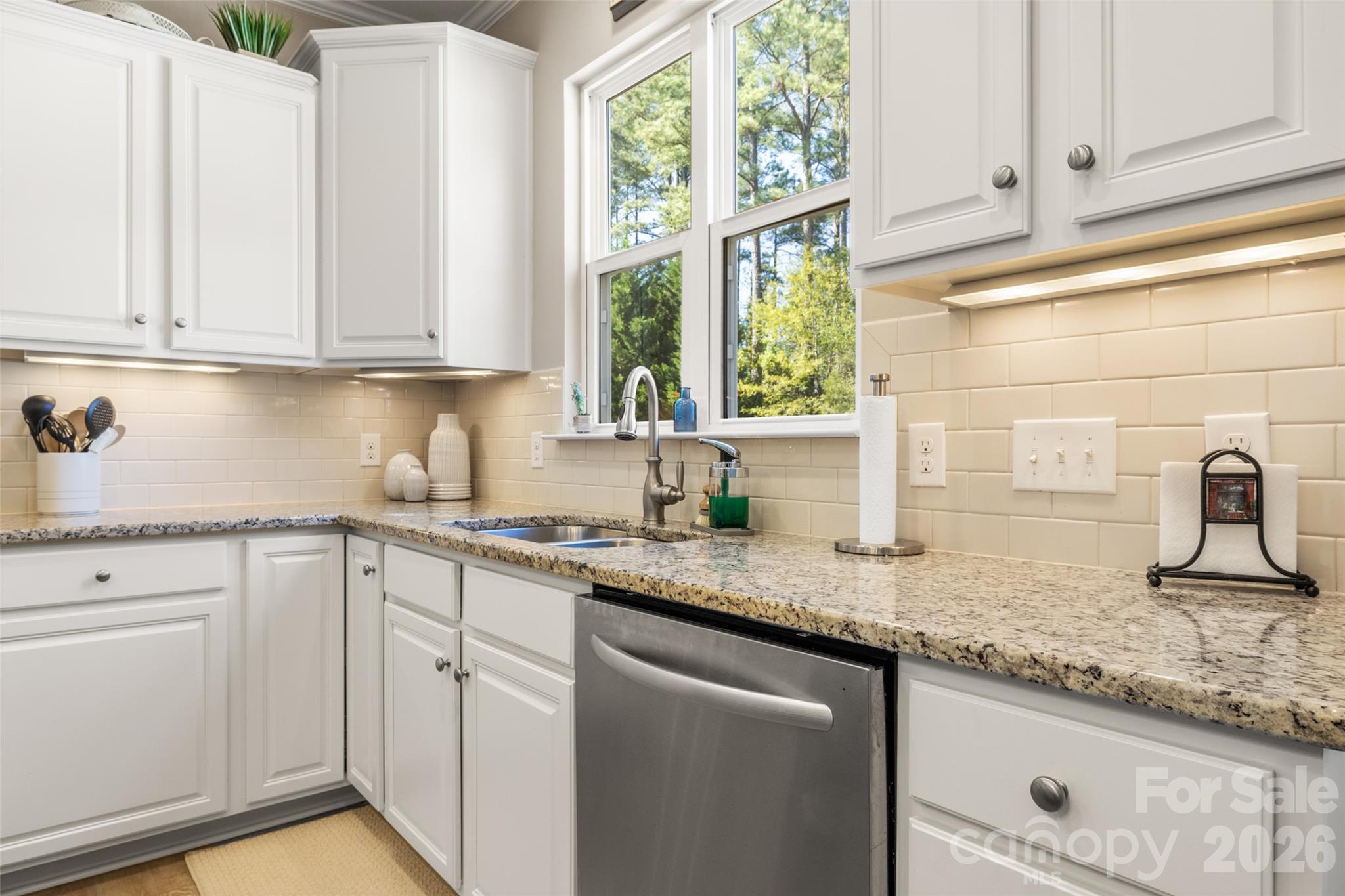 1002 Falling Leaf Street Indian Land, SC 29707 - Photo 8 of 45 a kitchen with granite countertop white cabinets and white stainless steel appliances with a window
