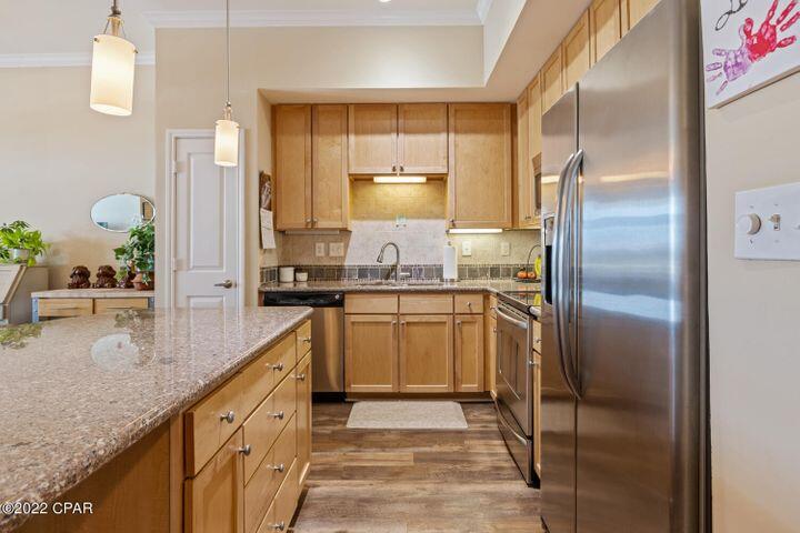 a kitchen with stainless steel appliances granite countertop a sink a stove and a refrigerator