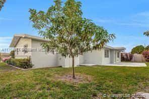 5391 West 9th Lane Hialeah, FL 33012 - Photo 7 of 22 a white house that has a tree in front of it