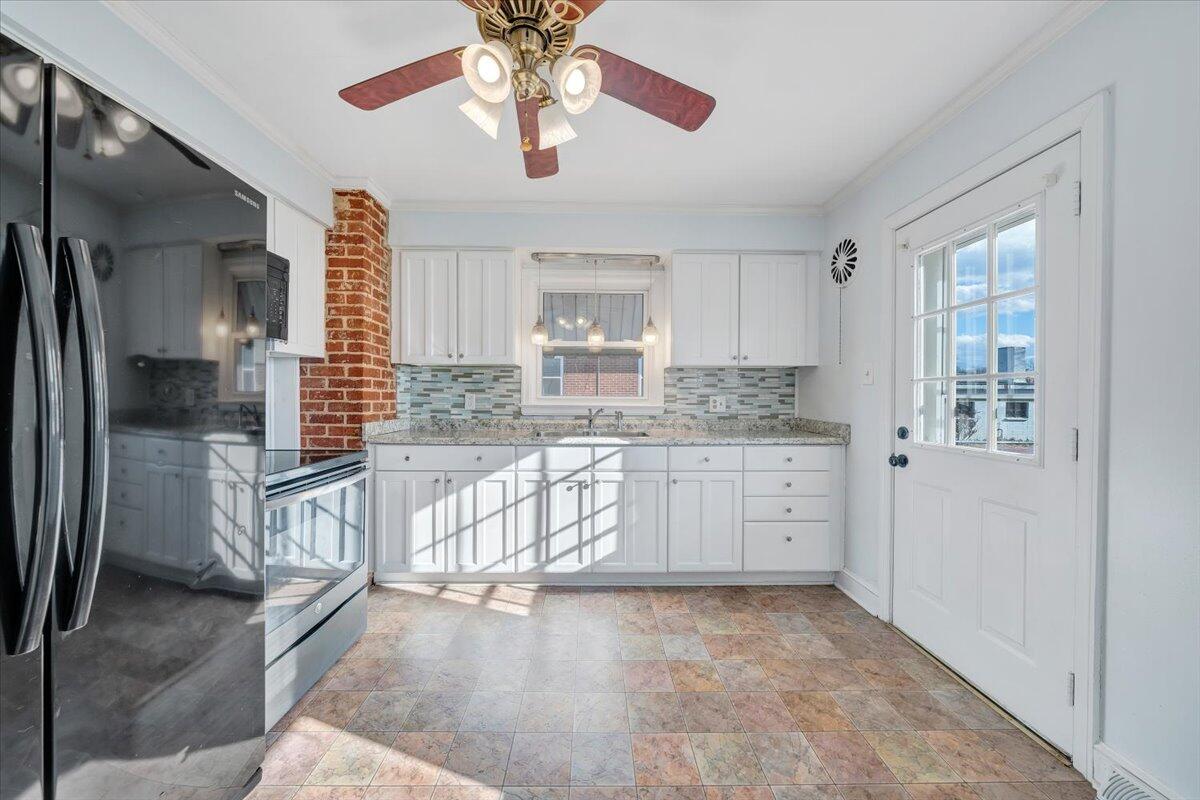 2346 Berkley Avenue Southwest Roanoke, VA 24015 - Photo 14 of 50 a kitchen with stainless steel appliances granite countertop a refrigerator a oven a sink and white cabinets with wooden floor