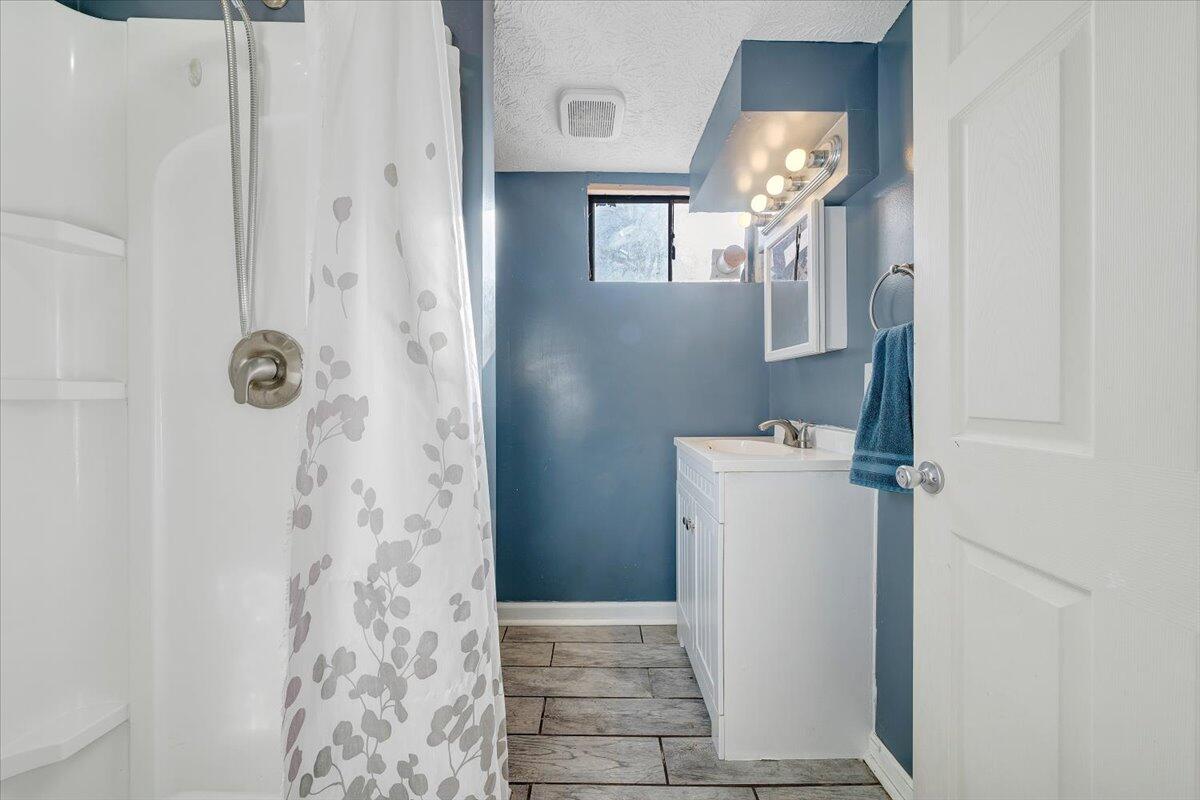 2346 Berkley Avenue Southwest Roanoke, VA 24015 - Photo 30 of 50 a bathroom with a sink a mirror and shower