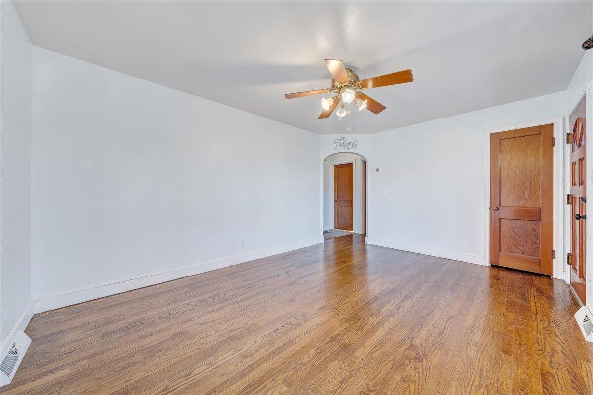 2346 Berkley Avenue Southwest Roanoke, VA 24015 - Photo 7 of 50 a view of an empty room with wooden floor and a ceiling fan