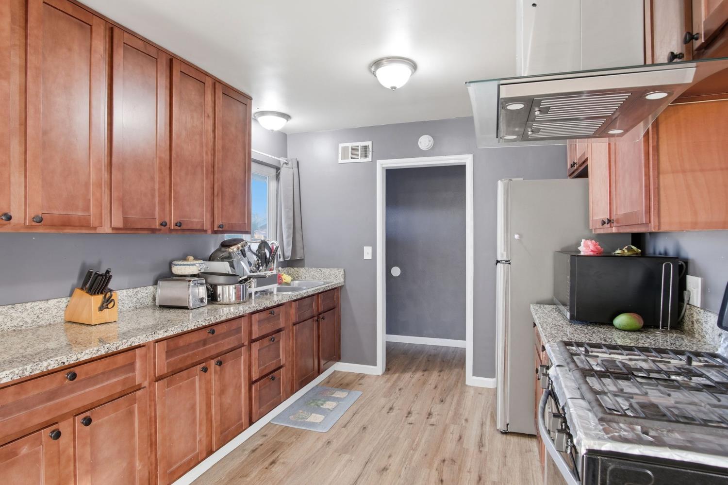 355 Harding Avenue Manteca, CA 95336 - Photo 8 of 21 a kitchen with stainless steel appliances granite countertop a sink stove and refrigerator