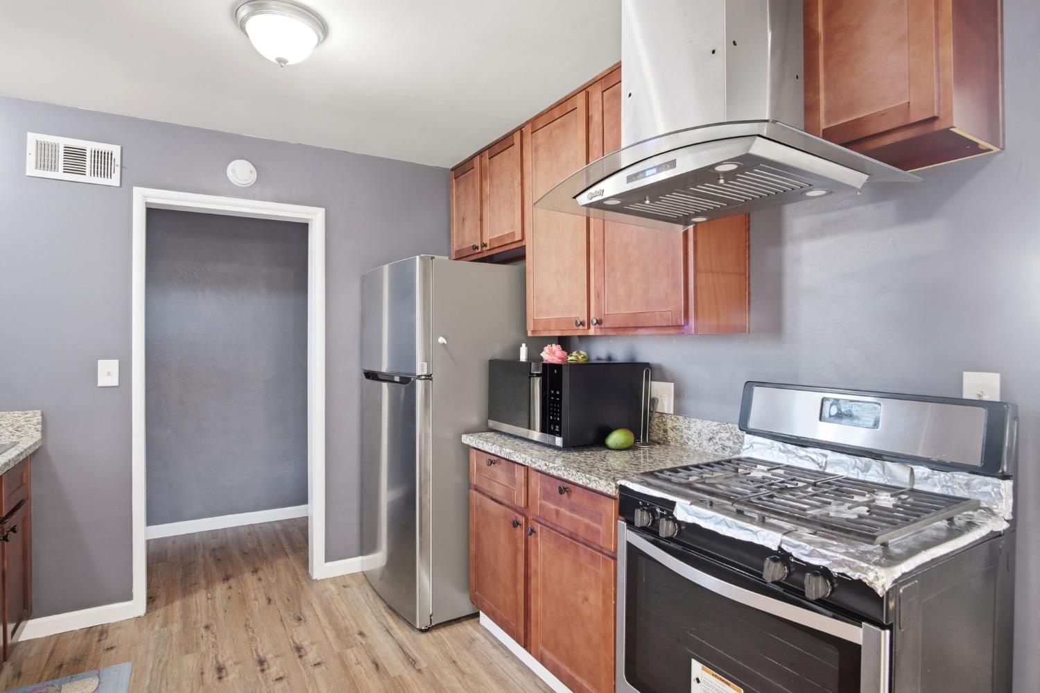 355 Harding Avenue Manteca, CA 95336 - Photo 9 of 21 a kitchen with stainless steel appliances granite countertop a stove a refrigerator and a sink