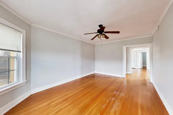 a view of empty room with wooden floor and window