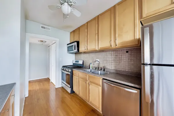 a kitchen with stainless steel appliances a refrigerator sink and cabinets