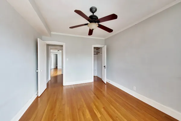 a view of empty room with wooden floor