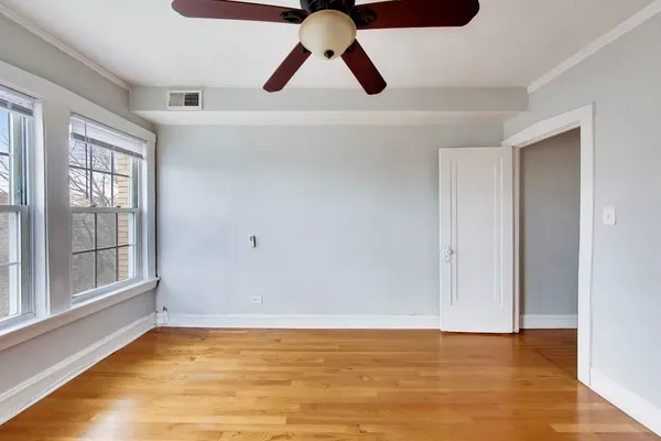 a view of an empty room with window and wooden floor