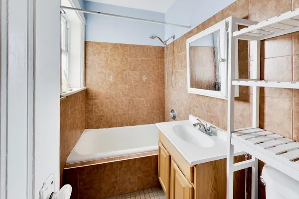 a bathroom with a tub sink and mirror
